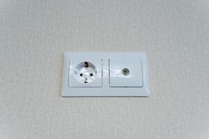 The wall prominently features a socket along with a switch, both of which are essential components for connecting power to various devices and controlling the room lighting effectively photo