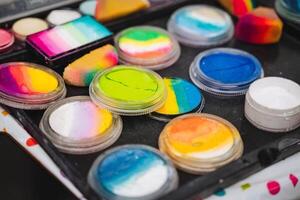 A large tray filled to the brim with a wide variety of colorful face paints, showcasing an array of vibrant hues and shades to choose from for creative artistic expression photo