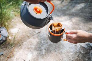 Taking part in outdoor activities like camping and brewing coffee can be a great way to kick off your day in nature by enjoying the process of making a delightful cup of coffee photo