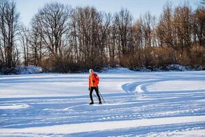 Skier skiing in the snow in the park, healthy outdoor recreation outside the city in winter. photo