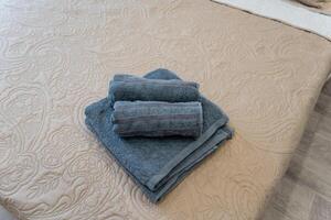 On the bed, there are three towels that are arranged in a neat and tidy stack, contributing to a clean, organized, and visually appealing atmosphere in the surrounding room area photo