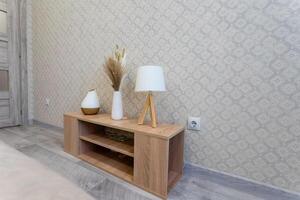 In a warm and cozy living room setting, a beautiful wooden table proudly displays an elegant lamp along with lovely vases, artfully arranged for everyone to appreciate and admire photo