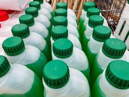 A collection of green and white bottles that feature green caps, indicating that they are likely designed for various types of fluids or liquids, including possibly water or chemicals photo