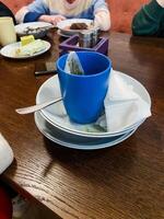 un vibrante azul taza es esmeradamente metido encima un pulcramente arreglado apilar de platos, creando un hermosa monitor de vajilla Perfecto para ninguna comida ajuste o especial ocasión foto