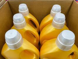 A rectangular box packed with vibrant yellow bottles, each topped with white caps, indicating the various contents within, likely filled with delicious liquids such as syrup or juice photo