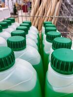 You can observe a row of distinct green and white bottles that feature green lids, showcasing their unique design and functionality, perfect for containing various types of liquids photo