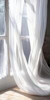 A white curtain is hanging in front of a window. photo