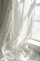 A white curtain is hanging in front of a window photo