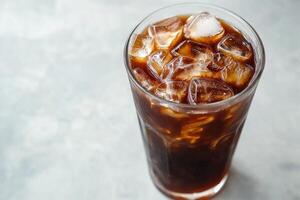 A glass of iced coffee with ice cubes in it. photo