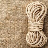 Gritty natural fibers. Coiled rope on burlap background for rustic decor and crafts. photo