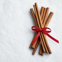 Cinnamon sticks bundle. Cinnamon sticks tied with a red ribbon on a white background. photo