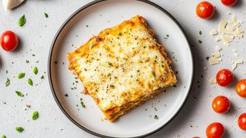 Layered lasagna slice. Delicious lasagna slice with cherry tomatoes on a plate. photo