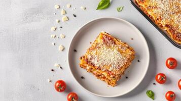 Layered lasagna slice. Delicious lasagna served with fresh basil and cherry tomatoes. photo
