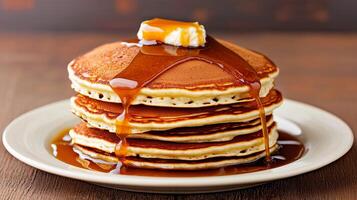 Smooth caramel drizzle. Stack of pancakes drizzled with syrup and topped with butter. photo