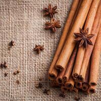 Cinnamon sticks bundle. Cinnamon sticks and star anise on burlap fabric background. photo