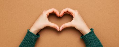 Brown background valentine s day concept. Hands forming a heart shape on a textured background. photo