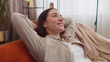 Tired lazy woman enjoy relaxing on home sofa resting napping after hard working day, closed her eyes video