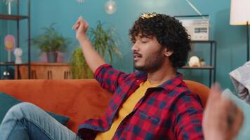 Tired indian man lying down on comfortable couch, taking a rest, daytime nap relaxing falling asleep video