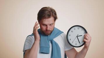 Confused man with anxiety checking time on clock, running late to work, being in delay, deadline video
