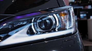 Closeup left car headlight side span of the camera. Stock. Modern techonology auto details with led and xenon elements inside. video