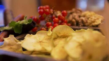 Close up of the table with dried slices of apples, red cranberries, mint leaves, and walnuts. Stock. Healthy vegan diet and nutrition concept, fruits, berries, and nuts lying on the table. video