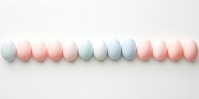 Pastel colored eggs aligned in a row against white background, minimalist easter concept photo