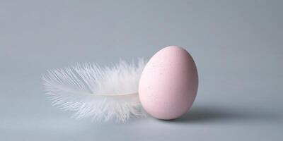 Pink egg with white feather on a neutral background symbolizing fragility and elegance photo