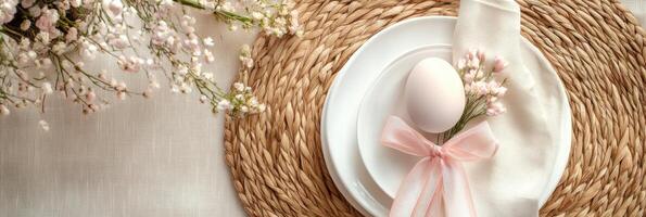 Elegant easter table setting with egg and pink ribbon on woven placemats photo