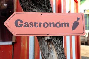The Gastronom Signpost Serving as a Guide to Various Culinary Delights and Experiences photo
