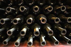 Beautiful and Elegant Wine Bottles Delightfully Stacked in a Charming Vintage Cellar Space photo