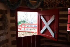 This charming rustic barn window features delightful red accents paired with a crossbar design photo