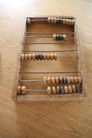A classic wooden abacus sits beautifully displayed on a tabletop for all to see photo