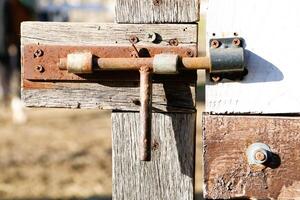 A Rustic Lock Mounted on a Weathered Wood Gate, Evoking a Sense of Timeless Charm and Character photo