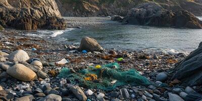 Coastal pollution with discarded fishing nets and debris on rocky shoreline photo