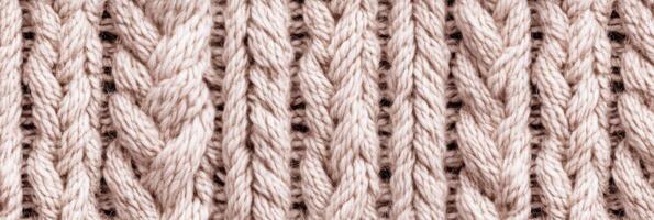 Close-up of beige knitted woolen textile, showcasing intricate patterns and weaving photo