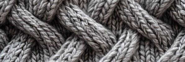 Close-up of gray woolen knitted fabric texture with braided pattern photo
