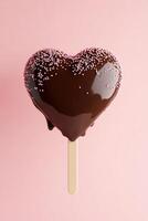 A delicious heart-shaped ice cream bar coated in glossy chocolate and topped with colorful sprinkles, set against a soft pink gradient background perfect for sweet occasions photo