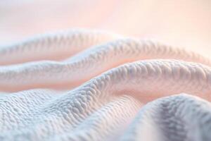 A soft glowing quilt is draped gracefully over a surface, showcasing inviting textures that evoke feelings of comfort and relaxation. The neutral gradient background enhances the soothing atmosphere photo