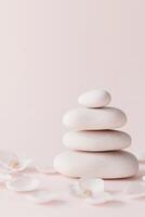 A harmonious arrangement of smooth stones with subtle glowing edges is beautifully surrounded by delicate floral petals. This peaceful setting on a soft pastel gradient evokes tranquility and luxury photo
