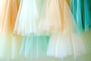 Elegant display of soft tulle skirts in white, ivory, and pale blue illuminated by warm light for a dreamy atmosphere photo