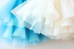 Soft tulle skirts elegantly displayed in shades of white, ivory, and pale blue illuminated by gentle warm light for a dreamy atmosphere photo