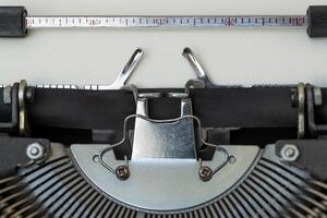 Old typewriter showing keys, ribbon and blank paper photo