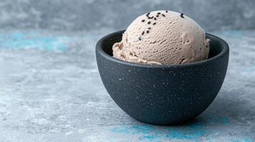 Close up of a scoop of delicious sesame ice cream in a dark bowl photo