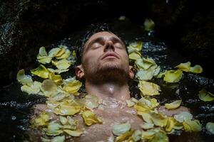 Man relaxing in a bath with rose petals photo