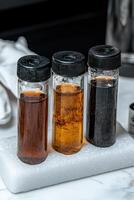 Three vials of different colored liquids on a white surface photo