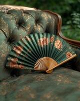 Green floral hand fan on antique chair photo