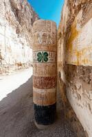 Ancient column with hieroglyphs and a four leaf clover photo