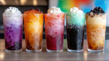 Five colorful shaved ice drinks with whipped cream and boba pearls photo