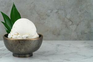A scoop of vanilla ice cream in a rustic bowl photo