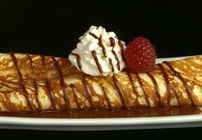 Delicious crepe with chocolate sauce, whipped cream, and raspberry photo